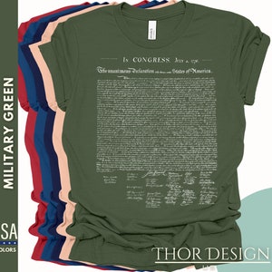 May include: A green t-shirt with the text "In Congress, July 4, 1776" and the full text of the Declaration of Independence printed on the front. The text is in white and the t-shirt is a military green color.