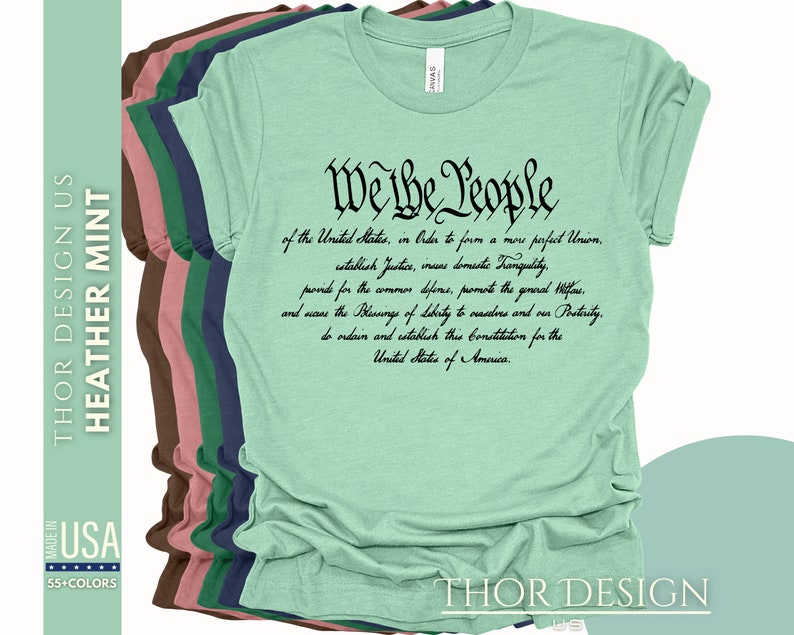 May include: A green t-shirt with the text "We the People" in black lettering. The text is a quote from the US Constitution. The shirt is available in a variety of colors.