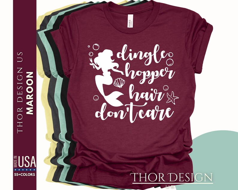May include: A maroon t-shirt with a white graphic of a mermaid with the text "dingle hopper hair don't care".