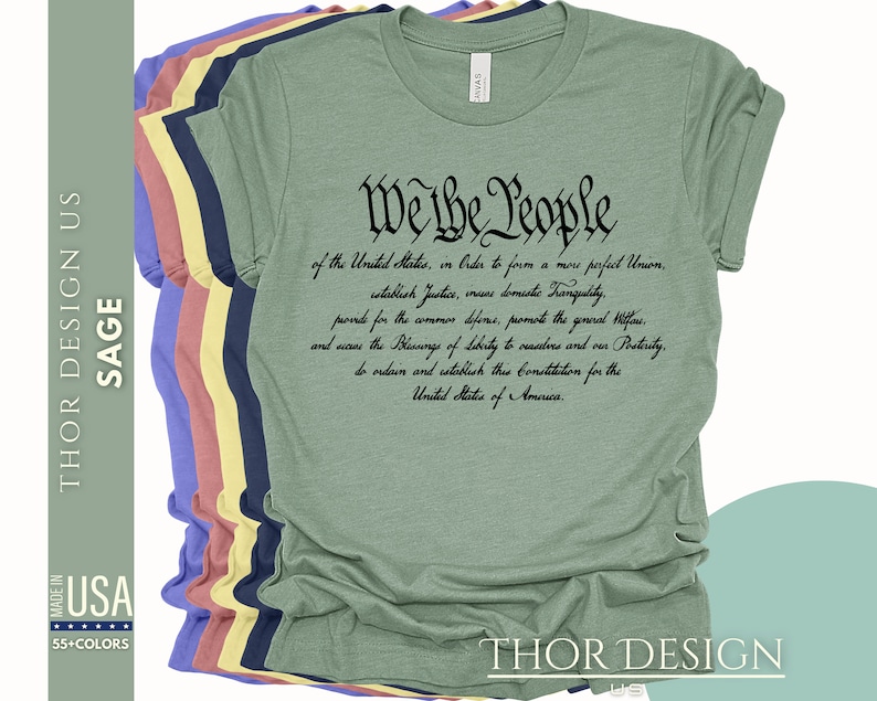 May include: Sage green t-shirt with the text "We the People" and the preamble to the United States Constitution printed in black.