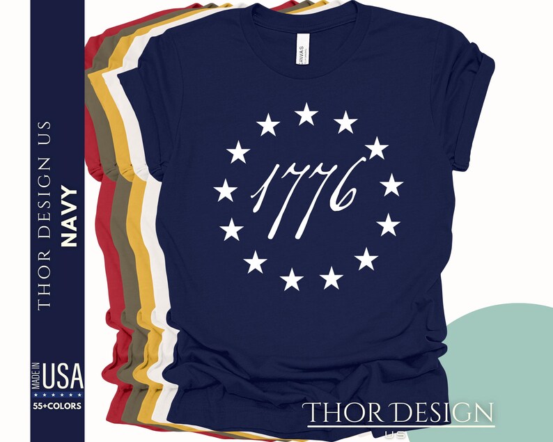 Pode incluir: Camiseta azul marinho com um c&iacute;rculo branco de estrelas e o texto "1776" em uma fonte cursiva.