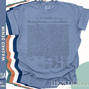 May include: A light blue t-shirt with the text "In CONGRESS, July 4, 1776. The unanimous Declaration of the thirteen united States of America." printed on the front. The text is in black and is a replica of the Declaration of Independence.
