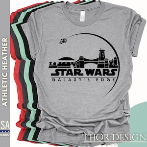 May include: A heather gray t-shirt with a black silhouette of the Star Wars Galaxy's Edge skyline. The text "Star Wars Galaxy's Edge" is printed below the skyline.