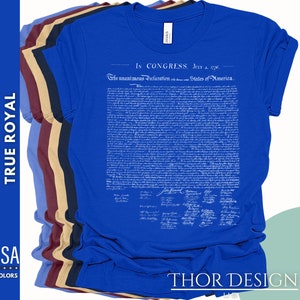 May include: A blue t-shirt with the text "In Congress, July 4, 1776. The unanimous Declaration of the thirteen united States of America." printed on the front. The text is in white and is a replica of the Declaration of Independence.