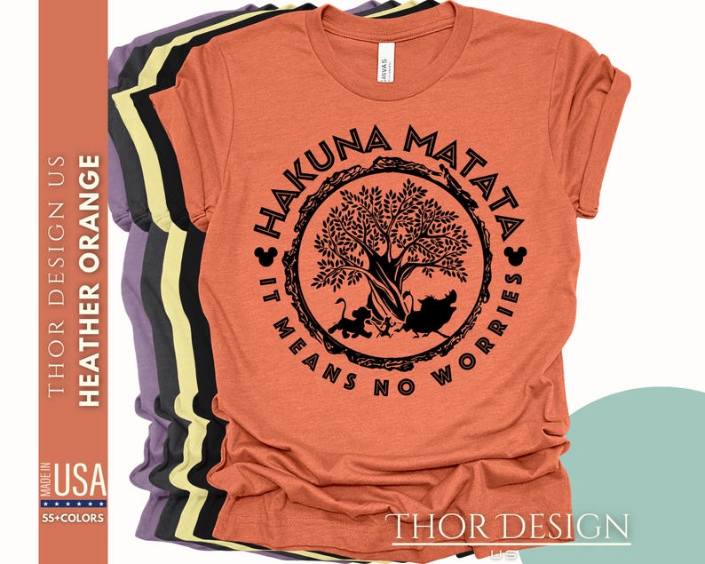 Puede incluir: Una camiseta naranja jaspeada con un gr&aacute;fico negro de un &aacute;rbol y el texto "Hakuna Matata It Means No Worries" en un c&iacute;rculo.