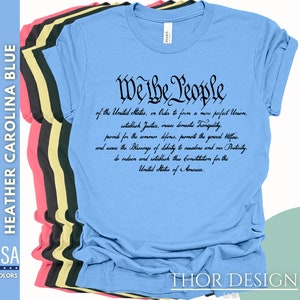 May include: A light blue t-shirt with black text that reads "We the People" followed by the preamble to the United States Constitution.