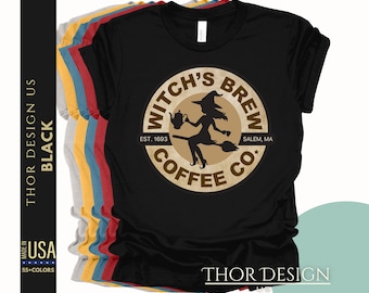 Può includere: Maglietta nera con un logo marrone e bianco che dice "Witch's Brew Coffee Co." con una strega che vola su una scopa e un calderone. Il logo dice anche "Est. 1693" e "Salem, MA".