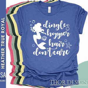 May include: A royal blue t-shirt with a white graphic of a mermaid with the text "dingle hopper hair don't care".