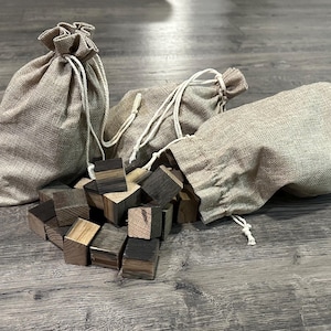 May include: Three burlap sacks filled with small wooden blocks. The blocks are stained in shades of brown and black.