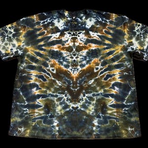 May include: A short-sleeved t-shirt with a distinctive tie-dye pattern. The shirt displays a symmetrical design in shades of brown, green, white, and navy blue. The shirt has a button-up neckline.