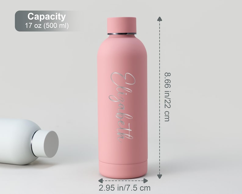 May include: A pink insulated water bottle with the name "Elizabeth" in a silver script. The bottle is 8.66 inches (22 cm) tall and 2.95 inches (7.5 cm) wide, with a capacity of 17 oz (500 ml).