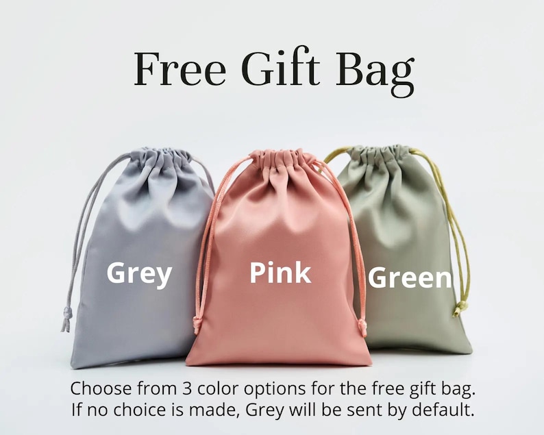 May include: Three satin gift bags in grey, pink, and green, each with a drawstring closure. The text "Free Gift Bag" is at the top. Below, the text indicates the color options and default color if no choice is made.