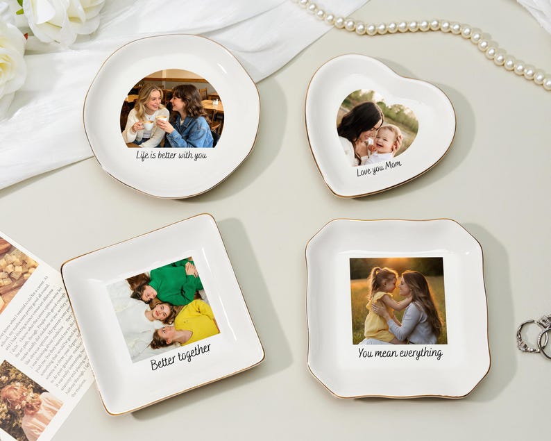 May include: Four white ceramic trinket dishes with gold rims. Each dish features a photograph and a handwritten message: "Life is better with you," "Love you Mom," "Better together," and "You mean everything."