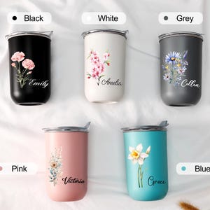 Op de afbeelding: Vijf ge&iuml;soleerde bekers in zwart, wit, grijs, roze en blauw. Elke beker heeft een bloemenontwerp en een naam. De zwarte beker heeft roze bloemen en de naam "Emily". De witte beker heeft roze bloemen en de naam "Amelia". De grijze beker heeft blauwe en gele bloemen en de naam "Collen". De roze beker heeft een bloemenontwerp en de naam "Victoria". De blauwe beker heeft een witte bloem en de naam "Grace".