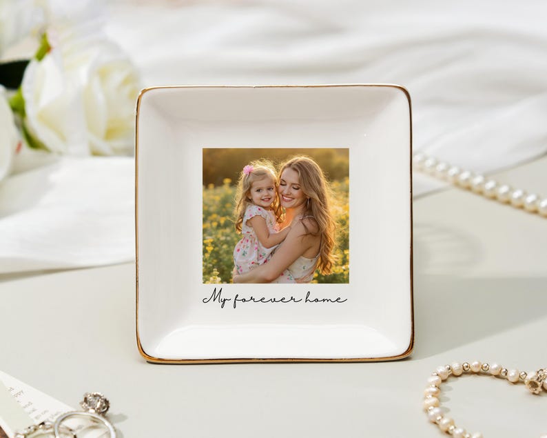 May include: A square, white ceramic trinket dish with a gold rim. The center features a color photograph of a woman and child. The words "My forever home" are written in script below the photo.