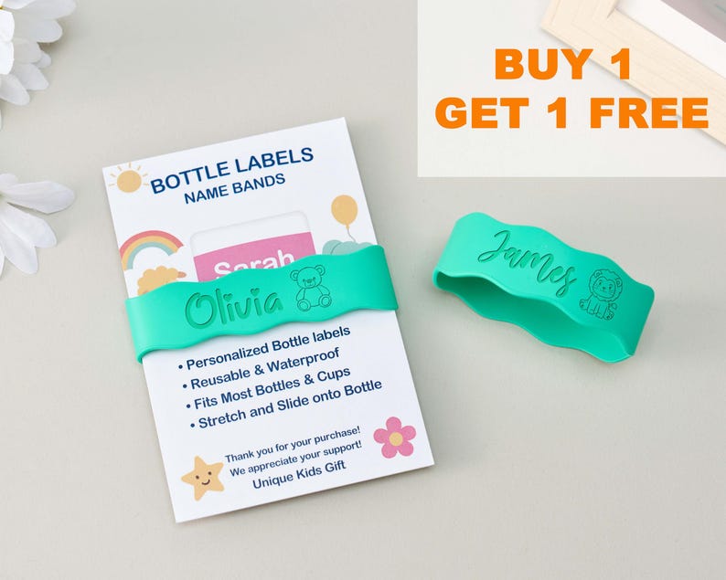 May include: Two teal silicone bottle bands with wavy edges, one wrapped around a white product card labeled BOTTLE LABELS NAME BANDS and the other loose. The bands feature engraved names Olivia and James with small bear and lion icons.