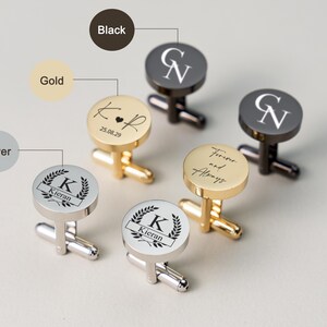 May include: Cufflinks in gold, silver, and black with personalized engravings. The gold cufflinks feature initials and a date, while the silver ones display a name within a laurel wreath. The black cufflinks have initials.