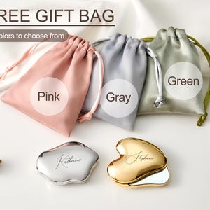 May include: A product shot featuring three drawstring gift bags in pink, gray, and green, with the text "3 colors to choose from" and "Free Gift Bag". Two personalized compact mirrors, one silver and one gold, are also displayed.
