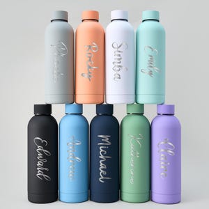 May include: A collection of ten insulated water bottles in various colors, including gray, orange, white, and blue. Each bottle has a silver name inscription. The bottles are arranged in two rows, with five bottles in each row.