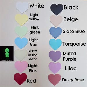 May include: A color chart featuring heart-shaped samples in various shades, including white, black, light yellow, beige, mint green, slate blue, light blue, turquoise, glow-in-the-dark, muted purple, light pink, lilac, red, and dusty rose. A small, glowing green figure is also shown.