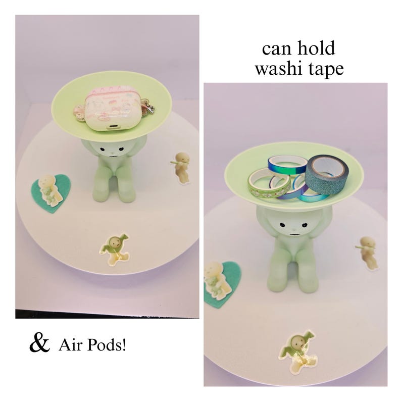 May include: A light green figurine holding a light green plate. The plate holds a pink and white Air Pods case and washi tape. The text says "can hold washi tape" and "& Air Pods!"