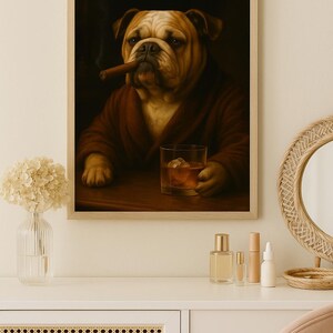 May include: Framed artwork featuring a bulldog in a brown robe, smoking a cigar, and holding a glass of whiskey with ice. The artwork has a dark background and is set on a wooden table. The image is a portrait style.