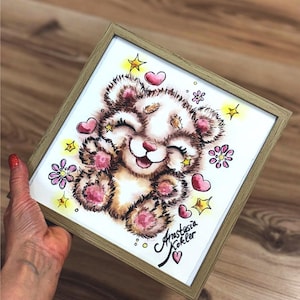 Könnte beinhalten: Ein gerahmtes Aquarellbild eines niedlichen Comic-Bären mit rosa Wangen und Pfoten. Der Bär ist umgeben von rosa Herzen, gelben Sternen und lila Blumen. Das Bild ist unten rechts mit "Anastasia Kokler" signiert.