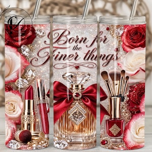 May include: A glittery tumbler with a design featuring red roses, diamonds, and makeup items. The text "Born for the Finer Things" is displayed in elegant script. The design includes lipstick, perfume, and nail polish.
