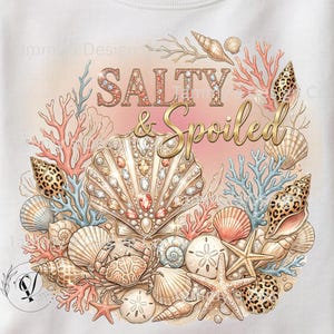 May include: White sweatshirt featuring a beach-themed design with seashells, coral, and starfish. The words "Salty & Spoiled" are written in decorative lettering. The artwork has a watercolor effect, with a pastel colour palette.