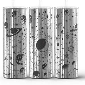 May include: Three stainless steel tumblers with a celestial design. Each tumbler features a black illustration of planets, stars, and constellations. The tumblers have a silver finish and include a clear straw.