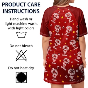 May include: A red t-shirt dress with a pattern of white cartoon figures, stars, and the name "Oriana." The dress has short sleeves and a crew neck. The product care instructions are also visible.