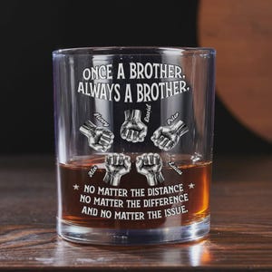 Op de afbeelding: Een helder whiskyglas met de tekst "ONCE A BROTHER, ALWAYS A BROTHER." en de namen Alex, Henry, David, Peter en Lucas. Het glas heeft vuistafbeeldingen en de quote "NO MATTER THE DISTANCE, NO MATTER THE DIFFERENCE, AND NO MATTER THE ISSUE."