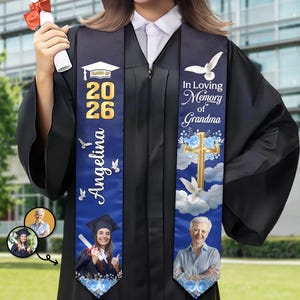 May include: A black graduation gown with a custom blue stole featuring the text "Class of 2026", "Angelina", and "In Loving Memory of Grandma". The stole includes images of a graduation cap, a gold cross, white doves, blue roses, and photos.