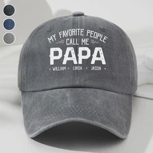 May include: Gray baseball cap with the text "MY FAVORITE PEOPLE CALL ME PAPA" in white. The names William, Linda, and Jason are printed below the word "PAPA". The cap has a curved brim and a button on top.