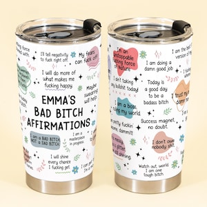 May include: A white stainless steel tumbler with a black lid. The tumbler is covered in colorful affirmations and the text "EMMA'S BAD BITCH AFFIRMATIONS". The design includes floral and star accents.