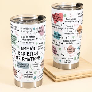 May include: Two stainless steel insulated tumblers with black lids. One tumbler has the text "EMMA'S BAD BITCH AFFIRMATIONS" and various affirmations. The other tumbler has affirmations like "I'm an Unstoppable Fucking Force of Nature."
