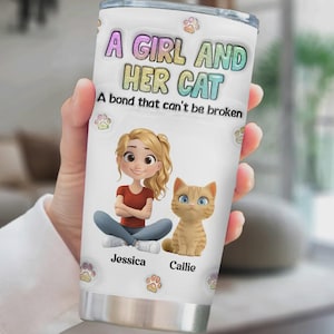 May include: White stainless steel travel mug with the text "A Girl and Her Cat" and a cartoon illustration of a girl and a cat. The mug also includes the names "Jessica" and "Callie" and paw prints.
