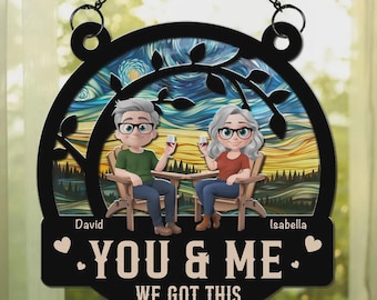May include: A black metal sign with a chain for hanging. It features a couple sitting in chairs, holding wine glasses, with a starry night background. The text reads "YOU & ME WE GOT THIS."