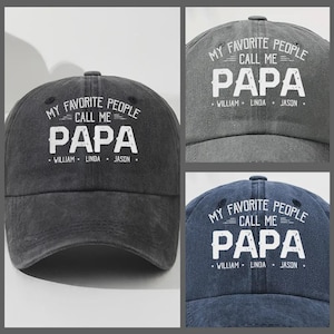 May include: Three baseball caps in different shades of gray and navy blue. Each cap has the text "MY FAVORITE PEOPLE CALL ME PAPA" in white, with the names "WILLIAM, LINDA, JASON" below. The caps are made of a soft, textured material.