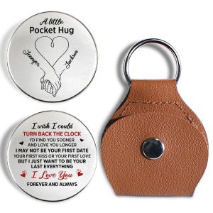 May include: Two circular silver-toned metal tokens and a brown leather keychain pouch with a silver snap button. One token features the text A little Pocket Hug, a heart, and two hands holding, with the names Jennifer and Jackson. The other token features the text I wish I could TURN BACK THE CLOCK, I'D FIND YOU SOONER AND LOVE YOU LONGER, I MAY NOT BE YOUR FIRST DATE, YOUR FIRST KISS OR YOUR FIRST LOVE, BUT I JUST WANT TO BE YOUR LAST EVERYTHING, I Love You, FOREVER AND ALWAYS.
