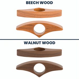 May include: Wooden book page holders in beech and walnut wood. The beech wood holders are a light brown color, while the walnut wood holders are a darker brown. Each holder has a circular hole for the finger and a pointed end.