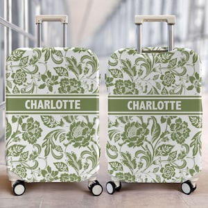 Peut inclure: Deux valises verticales arborant un motif floral damassé blanc et vert sauge. Chaque valise présente une bande horizontale vert sauge au centre avec le nom CHARLOTTE imprimé en lettres capitales blanches et une poignée télescopique argentée.