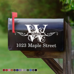 May include: Black mailbox with a red flag. The mailbox features a white monogram with the name "Williams" and the address "1023 Maple Street" in white lettering. Decorative scrollwork accents the design.