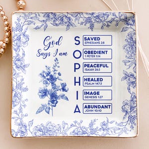 May include: Square white ceramic decorative tray with blue floral patterns and gold trim. The tray features the text "God Says I am SOPHIA" with associated words and Bible verses. A beautiful and inspirational home decor item.