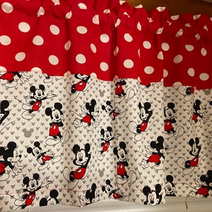 May include: Red and white polka dot fabric with a bottom border of white fabric with a repeating pattern of Mickey Mouse in black and red.