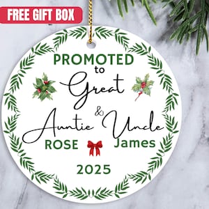 May include: A white, round Christmas ornament with a green leaf border and the text "PROMOTED to Great Auntie & Uncle Rose James 2025". The ornament has a red bow and holly accents.