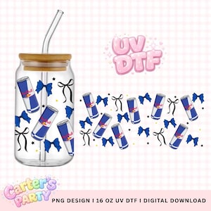 Puede incluir: Un vaso transparente en forma de lata con tapa de bambú y pajita de cristal curvada. El vaso está decorado con lazos azules, cintas negras y gráficos de latas de Red Bull. Un patrón repetido de los mismos elementos de diseño está a la derecha.