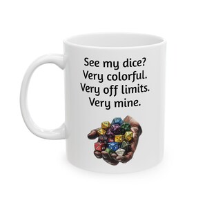 May include: White ceramic mug with a black text saying "See my dice? Very colorful. Very off limits. Very mine." and a colorful illustration of a hand holding a set of dice.