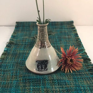 Mini bud vase that is pottery and is wheel thrown. Test piece that has multiple layers of slip, glazing etc.. honey bee design