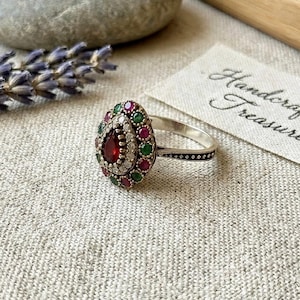 May include: A white ceramic mug with a black handle and the text "But First, Coffee" in a black, bold font. The mug is on a white surface.